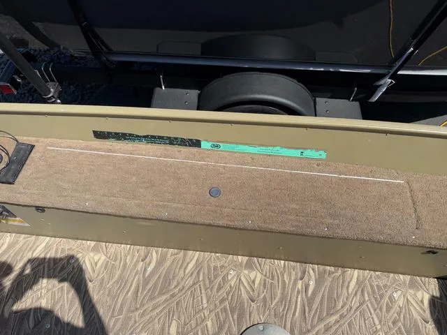 Slide: The Image of 2000 Lund 1475 Rebel boat interior with carpeted flooring and storage compartment. - 16