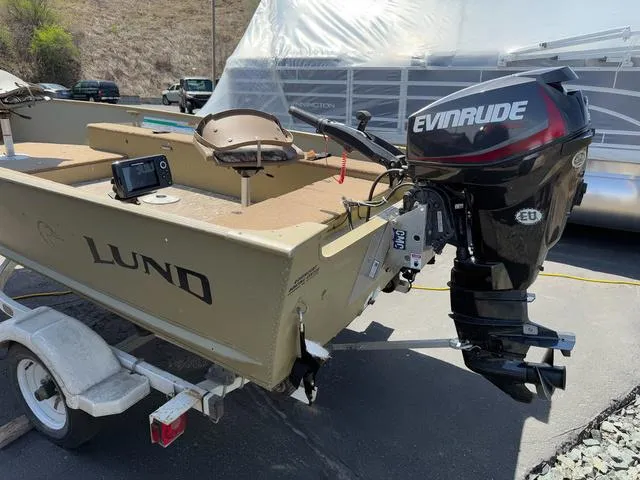 Slide: The Image of 2000 Lund 1475 Rebel boat with Evinrude motor on trailer, outdoor setting. - 4