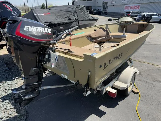 Slide: The Image of 2000 Lund 1475 Rebel boat with Evinrude motor on trailer, parked outdoors. - 5
