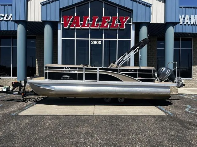 Slide: The Image of 2022 Bennington 22 SXSR Tri-Toon Pontoon boat displayed outside dealership. - 1