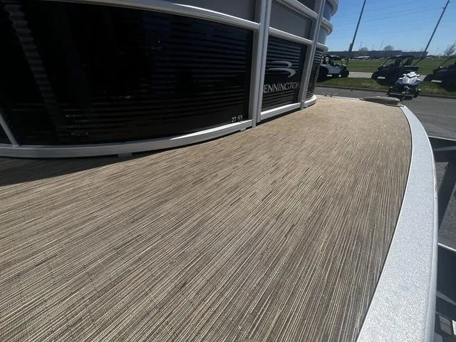 Slide: The Image of 2022 Bennington 22 SXSR Tri-Toon Pontoon with textured deck, parked outdoors. - 9