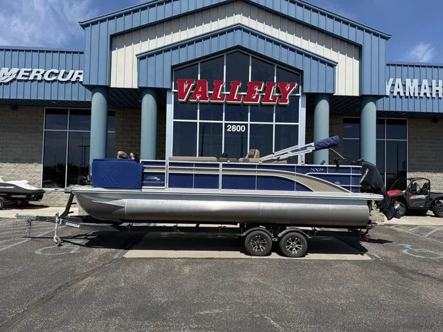 Slide: The Image of 2022 Bennington 23 SFXAPG pontoon boat cruising on open water. - 1