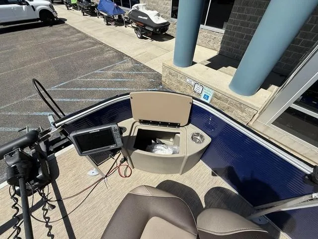 Slide: The Image of 2022 Bennington 23 SFXAPG boat interior with open storage compartment and control panel. - 11