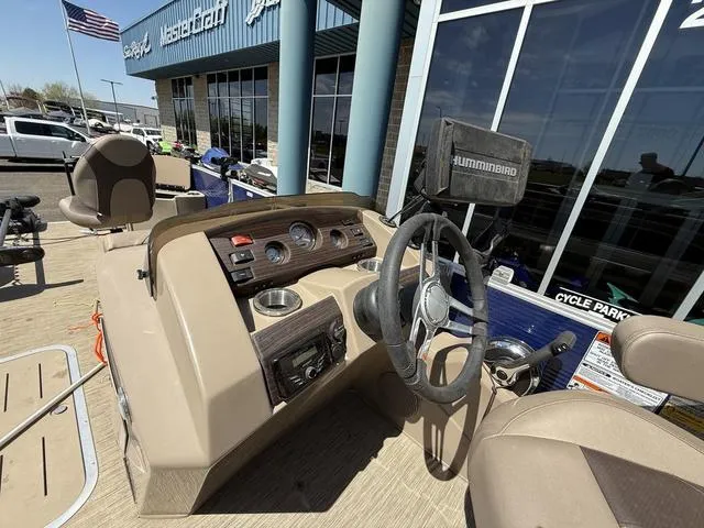 Slide: The Image of 2022 Bennington 23 SFXAPG boat dashboard with steering wheel and controls, outside dealership. - 19