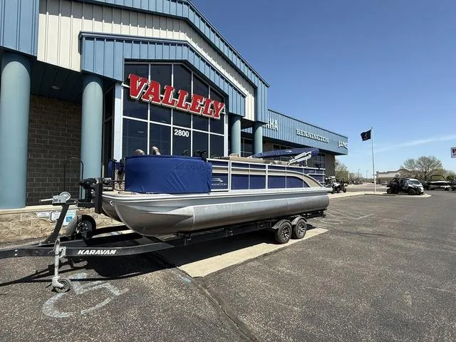 Slide: The Image of 2022 Bennington 23 SFXAPG pontoon boat on trailer outside dealership. - 2