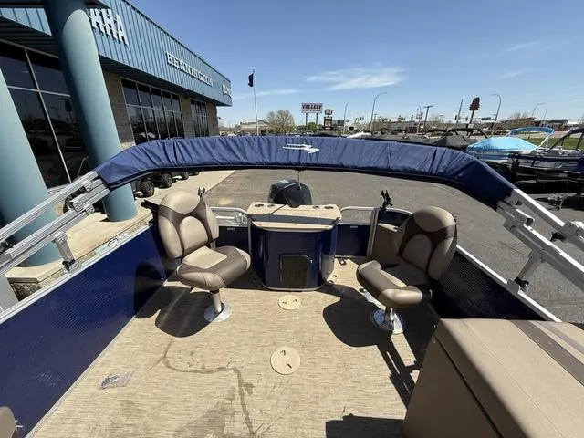 Slide: The Image of 2022 Bennington 23 SFXAPG pontoon boat with seating, canopy, and console, displayed outdoors. - 21
