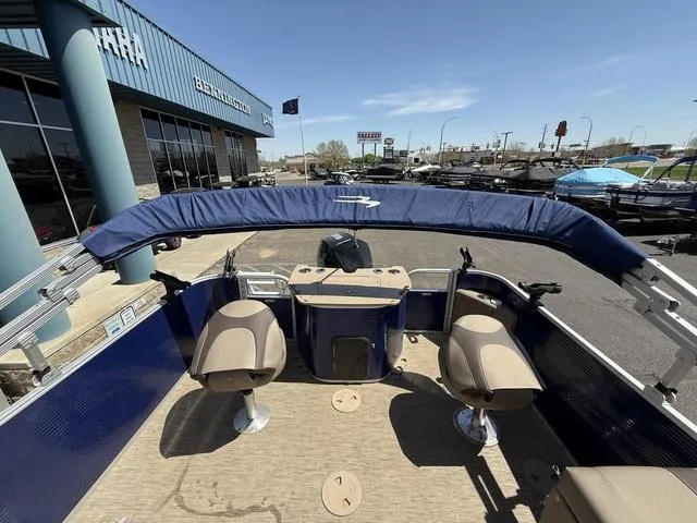 Slide: The Image of 2022 Bennington 23 SFXAPG pontoon boat interior with seating and console, displayed outdoors. - 22