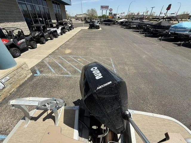 Slide: The Image of 2022 Bennington 23 SFXAPG boat with Mercury outboard motor in dealership parking lot. - 25