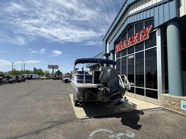 Slide: The Image of 2022 Bennington 23 SFXAPG pontoon boat parked outside a dealership under a clear sky. - 7