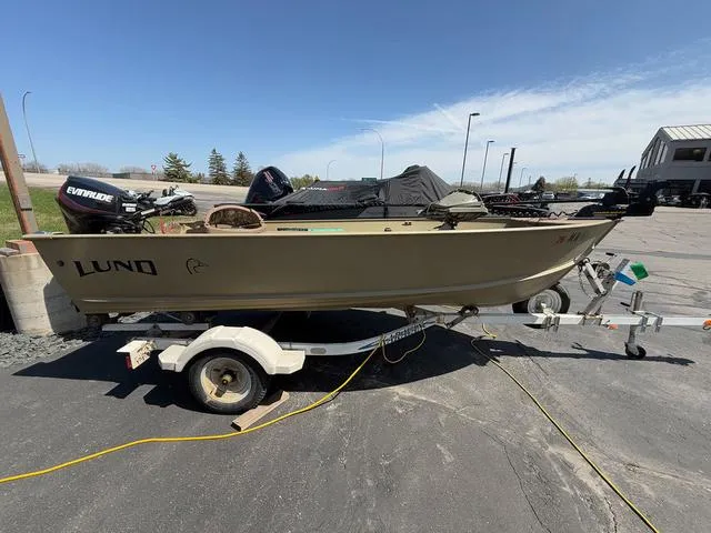 Slide: The Image of 2000 Lund 1475 Rebel boat on trailer, parked outdoors under clear sky. - 1