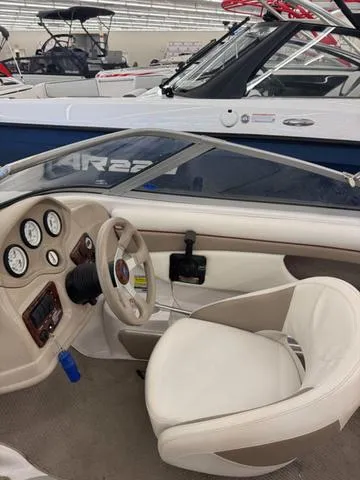 Slide: The Image of 2005 Four Winns 190LE boat interior with white seating and wooden steering wheel. - 11