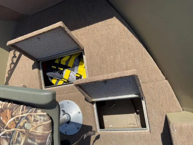 Slide: The Image of 2000 Lund 1475 Rebel boat interior with open storage compartments and life jacket. - 14