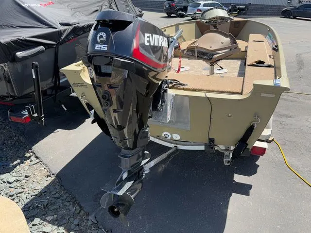 Slide: The Image of 2000 Lund 1475 Rebel boat with Evinrude 25 outboard motor in a parking lot. - 6
