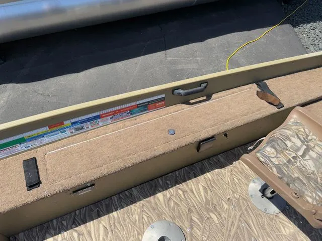 Slide: The Image of Interior view of a 2000 Lund 1475 Rebel boat, featuring seating and storage. - 9