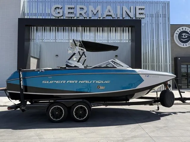 Slide: The Image of 2013 Nautique G23 boat in blue, parked at Germaine dealership. - 1