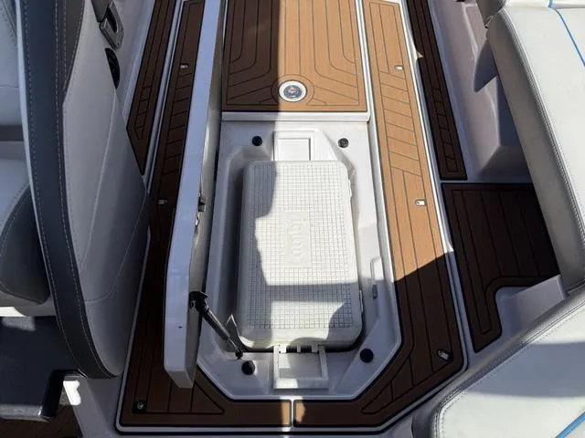 Slide: The Image of 2013 Nautique G23 boat interior with teak flooring and built-in cooler. - 13
