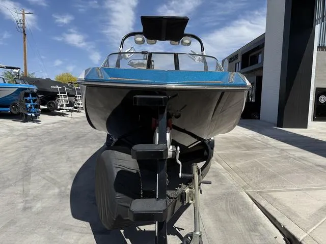 Slide: The Image of 2013 Nautique G23 boat on trailer, parked outdoors under clear sky. - 3