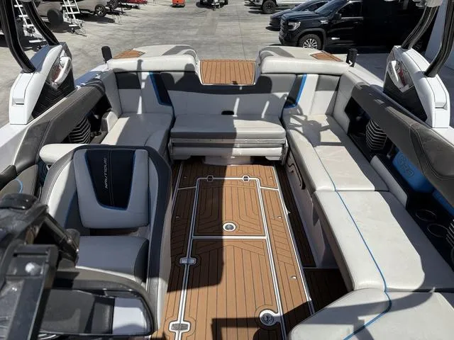 Slide: The Image of 2013 Nautique G23 boat interior with spacious seating and teak flooring. - 8