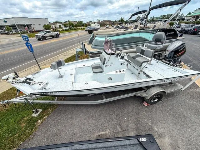 Slide: The Image of 2022 Xpress Boats H20B on trailer, parked outdoors, with seating and motor visible. - 6