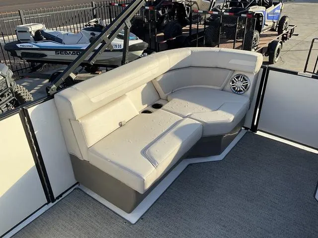 Slide: The Image of 2023 Hurricane FunDeck 2260 REF OB boat interior with beige seating and speaker. - 13