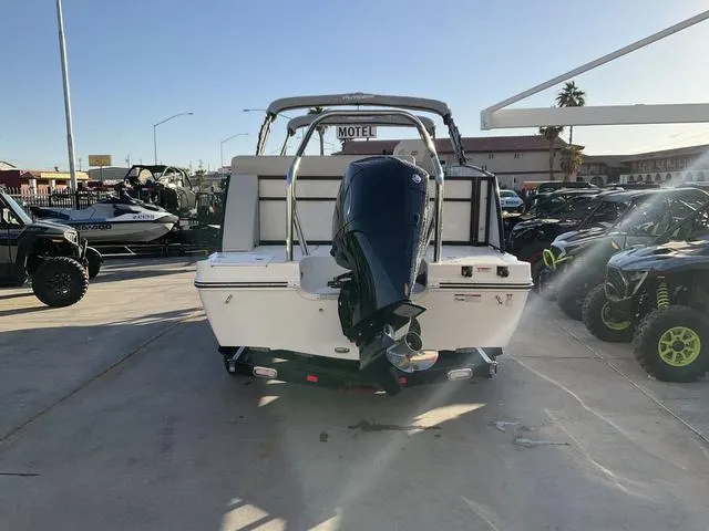 Slide: The Image of 2023 Hurricane FunDeck 2260 REF OB boat with outboard motor, parked outdoors. - 6