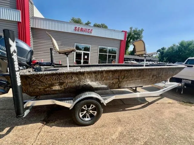 Slide: The Image of 2025 Xpress Boats HD 16 DB on trailer outside service center. - 3
