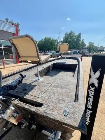 Slide: The Image of 2025 Xpress Boats HD 16 DB in camouflage, parked outdoors with seating and motor visible. - 4