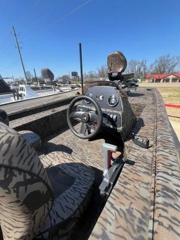 Slide: The Image of 2025 Xpress Boats XP180 with camo interior, steering wheel, and control panel under clear blue sky. - 10