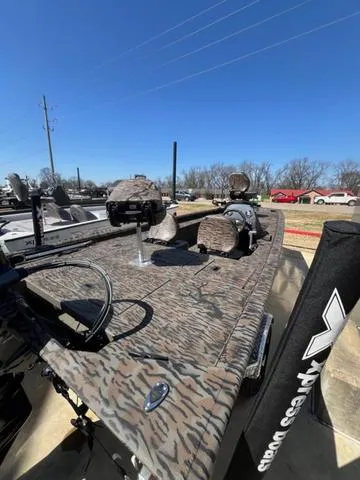 Slide: The Image of 2025 Xpress Boats XP180 with camouflage design, parked outdoors under clear blue sky. - 11