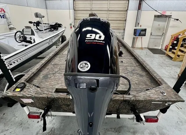 Slide: The Image of 2025 Xpress Boats XP180 with 90 horsepower engine in a garage setting. - 14