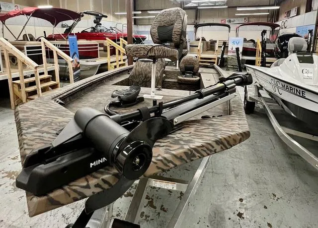 Slide: The Image of 2025 Xpress Boats XP180 with camouflage design and trolling motor in showroom. - 5