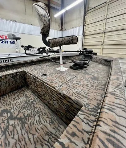 Slide: The Image of 2025 Xpress Boats XP180 with camo design in a garage setting. - 6