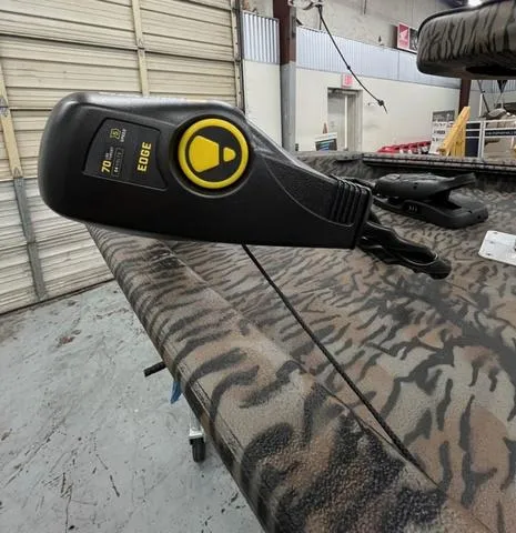 Slide: The Image of 2025 Xpress Boats XP180 with camo pattern and trolling motor in a garage setting. - 7