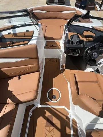 Slide: The Image of 2025 Axis Wake Research A225 boat interior with tan leather seats and modern dashboard. - 10