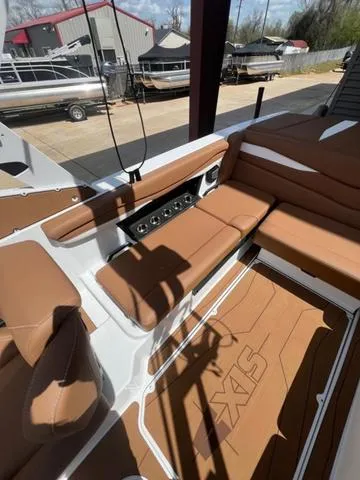 Slide: The Image of 2025 Axis Wake Research A225 boat interior with brown seating and control panel. - 15