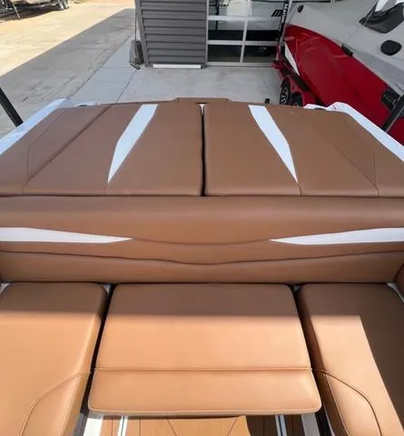 Slide: The Image of 2025 Axis Wake Research A225 boat with brown and white cushioned seating. - 16