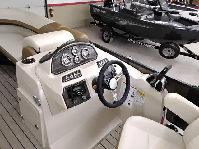 Slide: The Image of 2025 Lowe SS 210 TL boat dashboard with steering wheel and control panel in showroom. - 5