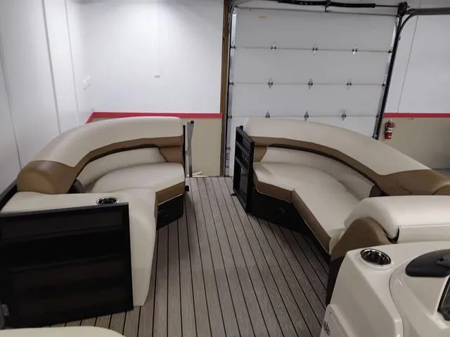 Slide: The Image of 2025 Lowe SS 210 TL pontoon boat interior with beige seating and wood-style flooring. - 6