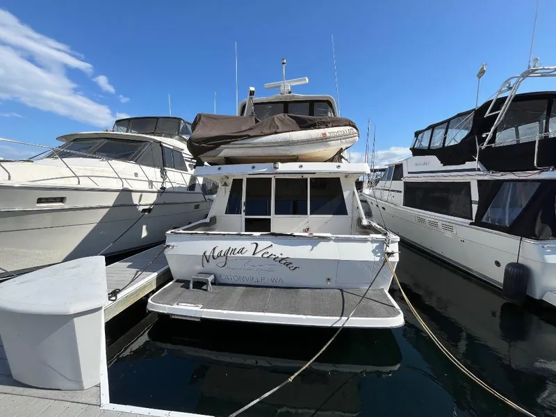 Slide: The Image of 1996 Bayliner 4788 yacht docked at marina under clear blue sky. - 1