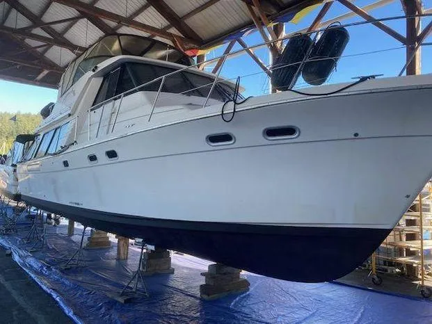 Slide: The Image of 1996 Bayliner 4788 yacht in dry dock, under a wooden shelter. - 11