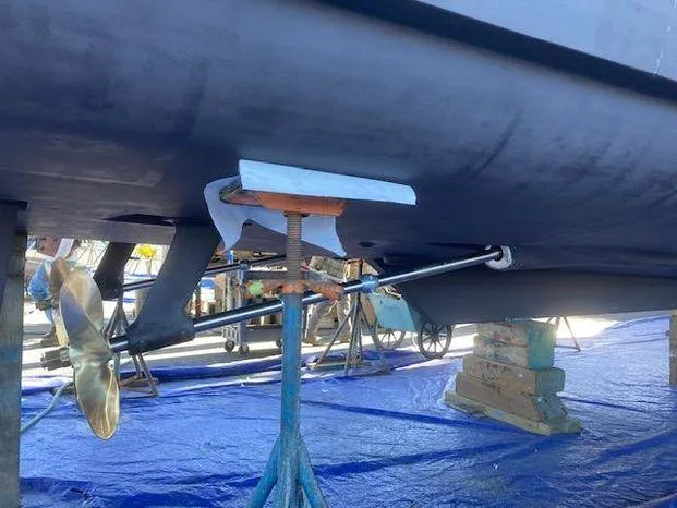 Slide: The Image of 1996 Bayliner 4788 yacht under maintenance, showing propeller and hull supported by stands. - 12