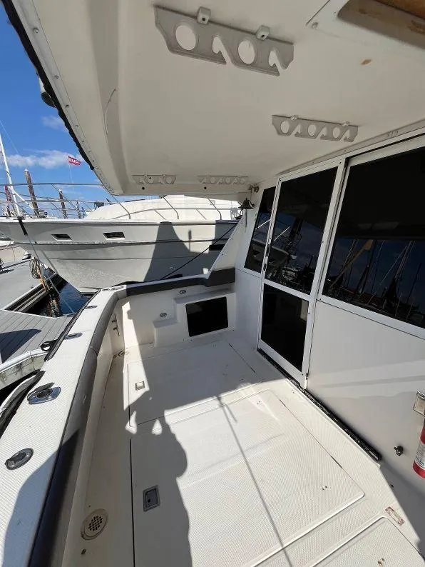Slide: The Image of 1996 Bayliner 4788 yacht deck with spacious seating area and marina view. - 16