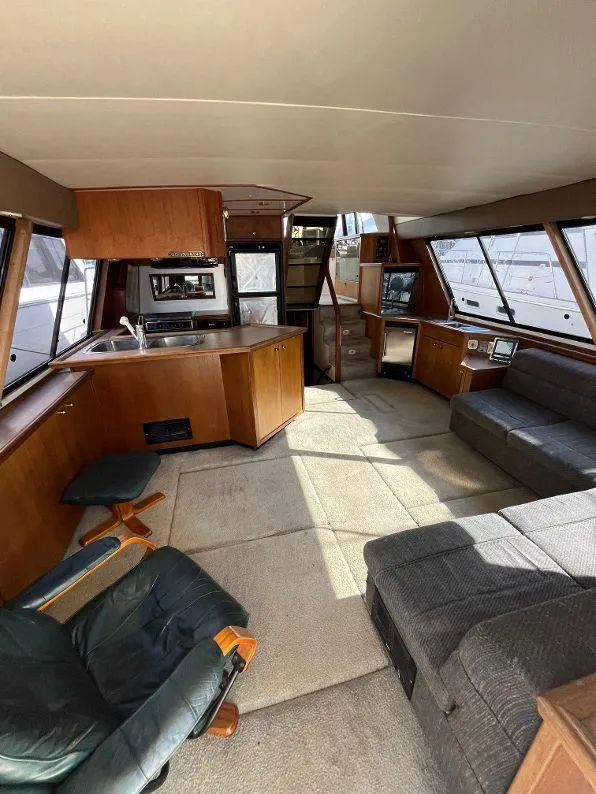 Slide: The Image of Interior of a 1996 Bayliner 4788 yacht with spacious seating and kitchen area. - 25