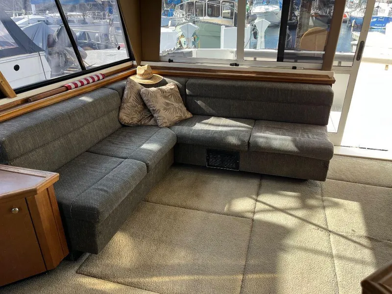 Slide: The Image of Interior of 1996 Bayliner 4788 yacht with gray L-shaped sofa and decorative pillows. - 26
