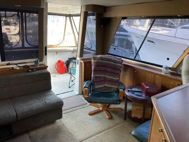 Slide: The Image of Interior of 1996 Bayliner 4788 yacht with seating, table, and large windows. - 28