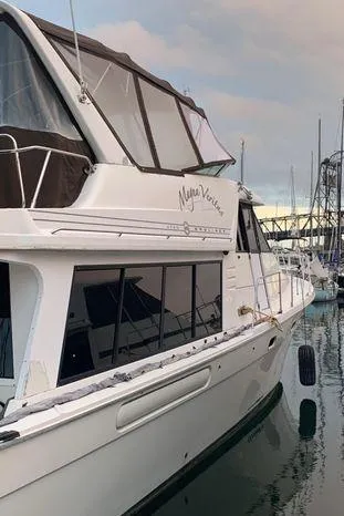 Slide: The Image of 1996 Bayliner 4788 yacht docked at marina, featuring sleek design and spacious cabin. - 4