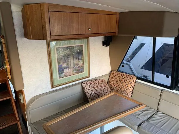 Slide: The Image of Interior of 1996 Bayliner 4788 yacht with seating, table, and wall art. - 43