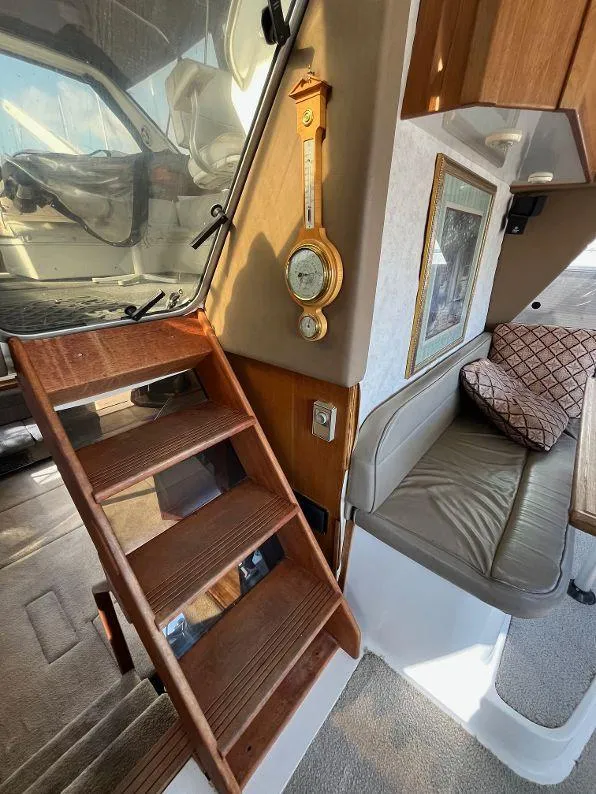 Slide: The Image of Interior of 1996 Bayliner 4788 yacht with wooden stairs and cozy seating area. - 44