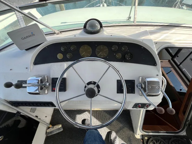 Slide: The Image of 1996 Bayliner 4788 helm with Garmin navigation, steering wheel, and control levers. - 45