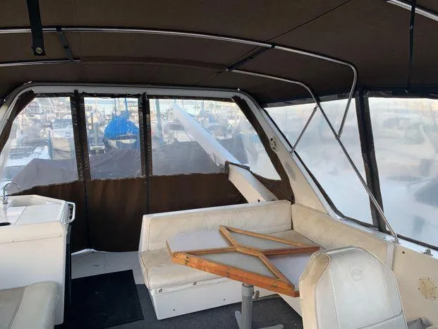 Slide: The Image of Interior of 1996 Bayliner 4788 yacht with seating and table, docked at marina. - 49